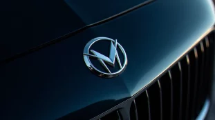 Emblème en V chromé sur calandre de voiture bleue marine, représentant le type de badge des autos avec logo V